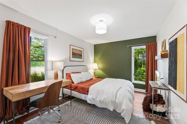 bedroom featuring wood finished floors and a desk