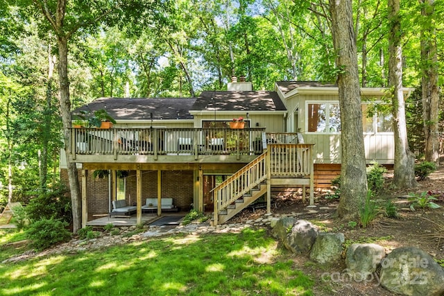 back of property with a wooden deck, stairs, a chimney, and a patio area