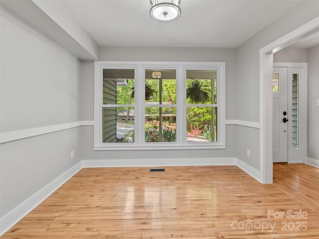 empty room with hardwood / wood-style flooring and baseboards