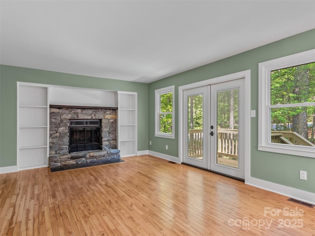 unfurnished living room with baseboards, french doors, and wood-type flooring