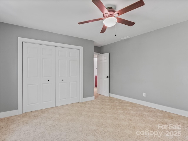 unfurnished bedroom with a closet, baseboards, carpet, and ceiling fan