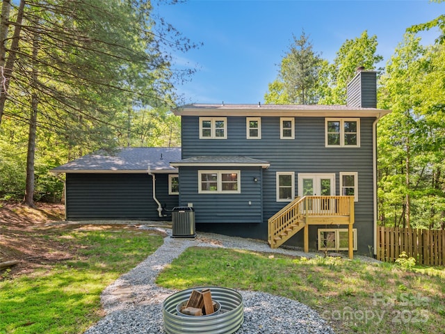 rear view of property featuring fence, a chimney, cooling unit, and stairs