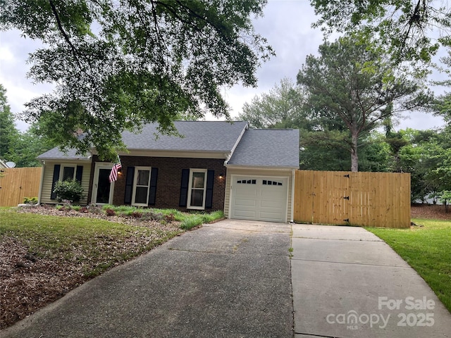 ranch-style home with fence, brick siding, concrete driveway, a garage, and a shingled roof