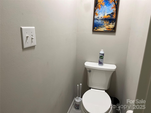 bathroom featuring baseboards and toilet