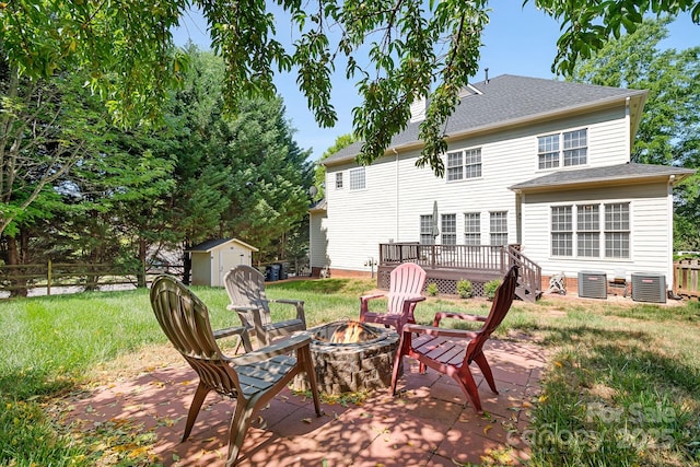 16028 Hallaton Dr, Huntersville, NC 28078 - back of house featuring an outdoor fire pit, central AC, a lawn, and a storage unit