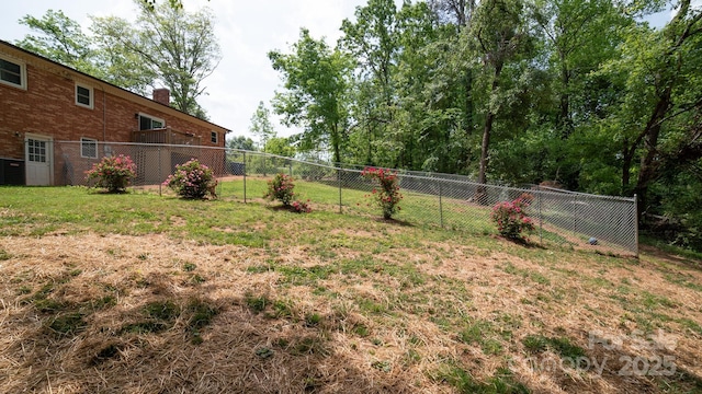 view of yard featuring central AC unit and fence