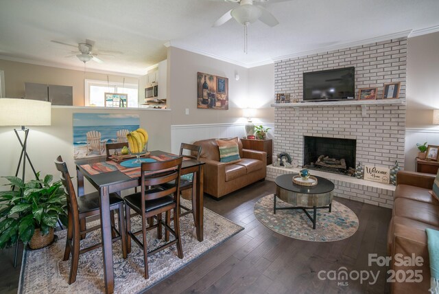living area featuring ornamental molding, wood finished floors, and ceiling fan