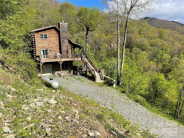 96 Trails End Ln, Maggie Valley, NC 28751 - view of side of property featuring stairway, a wooded view, dirt driveway, and a deck