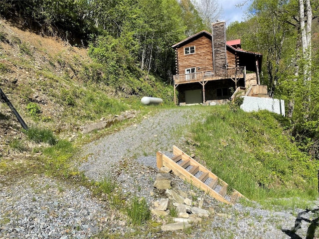 96 Trails End Ln, Maggie Valley, NC 28751 - view of yard with driveway, a wooden deck, a garage, and a forest view