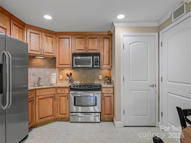 kitchen with brown cabinetry, visible vents, appliances with stainless steel finishes, and a sink