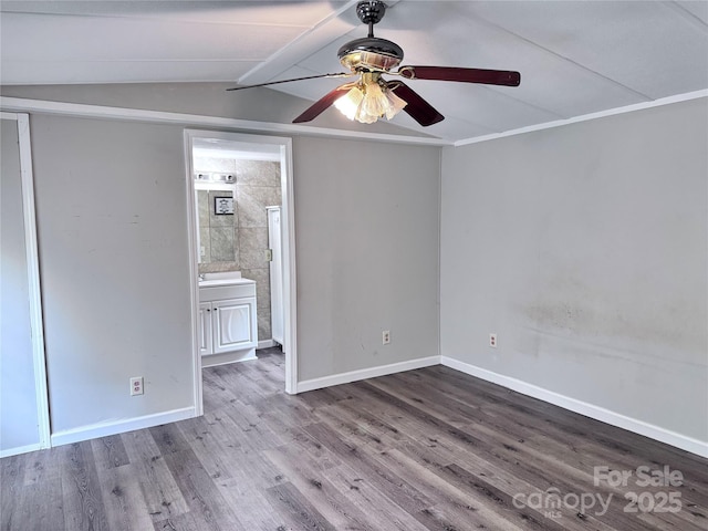 spare room with baseboards, wood finished floors, a ceiling fan, and lofted ceiling with beams