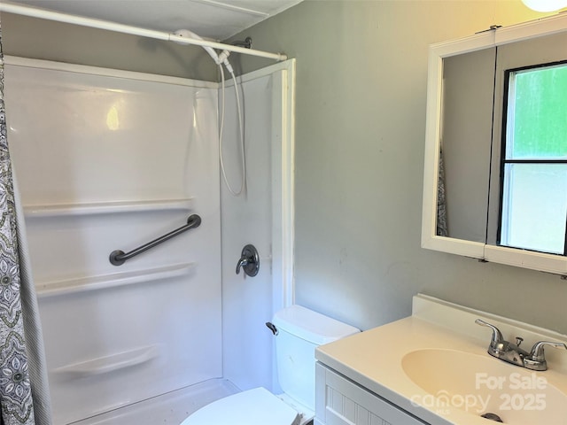 full bath featuring toilet, a shower with shower curtain, and vanity