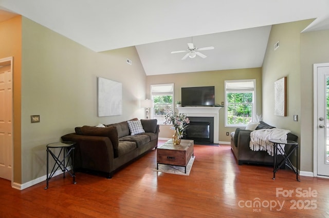 14402 Asheton Creek Dr, Charlotte, NC 28273 - living room featuring lofted ceiling, wood finished floors, baseboards, ceiling fan, and a fireplace with flush hearth