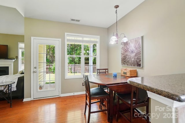 14402 Asheton Creek Dr, Charlotte, NC 28273 - dining area featuring wood-type flooring, a chandelier, baseboards, and a fireplace