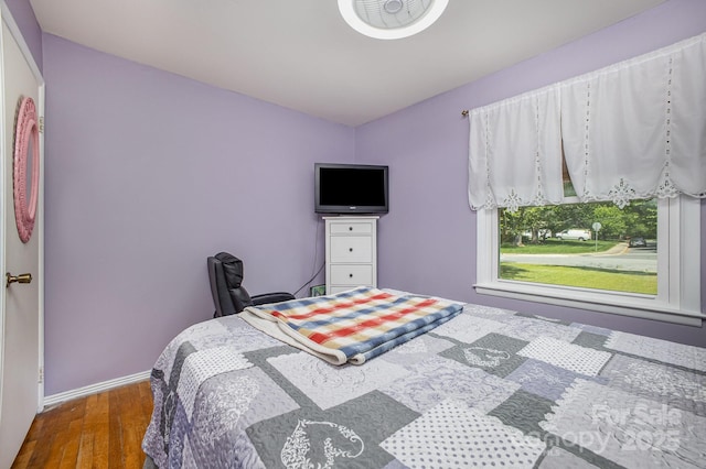 bedroom with wood finished floors and baseboards