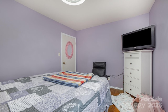 bedroom featuring baseboards and wood finished floors