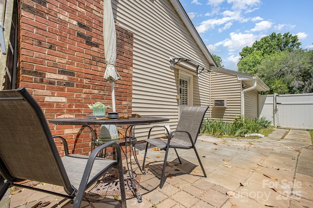 view of patio / terrace with outdoor dining space, fence, and a gate