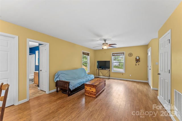 living area featuring light wood finished floors, ceiling fan, and baseboards