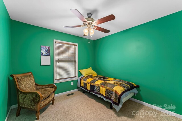 carpeted bedroom featuring baseboards and ceiling fan