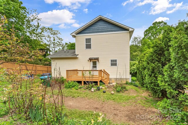 rear view of house featuring a deck and fence