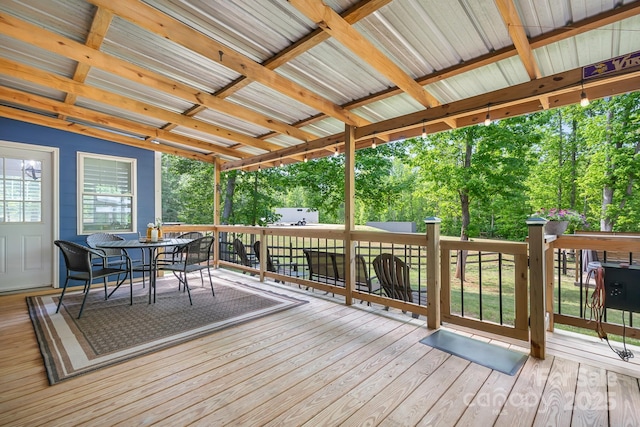 deck featuring outdoor dining area and view of scattered trees
