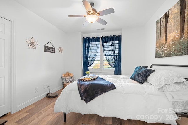bedroom with baseboards, wood finished floors, and ceiling fan