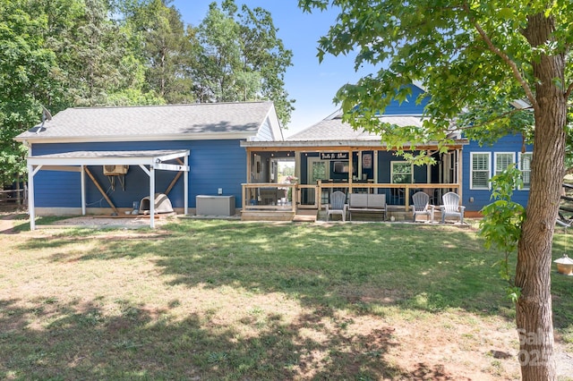 back of property with a lawn, an outdoor hangout area, a shingled roof, and a patio