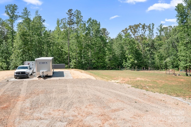 view of dirt / gravel road featuring a view of trees