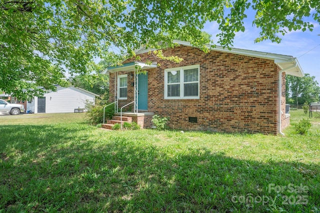 view of front of house featuring brick siding, a front lawn, and crawl space