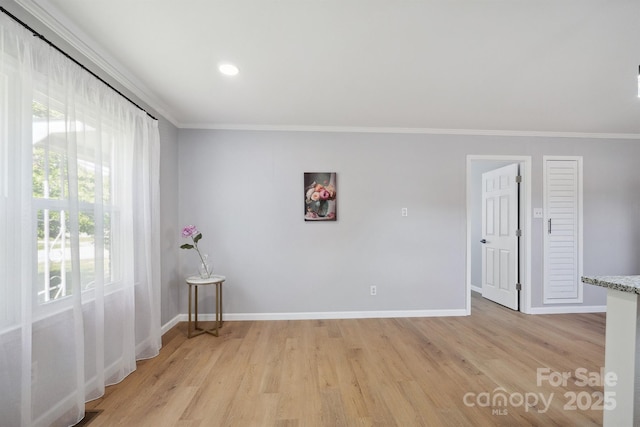 spare room with baseboards, recessed lighting, light wood finished floors, and crown molding