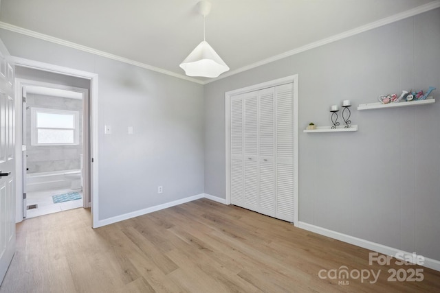 unfurnished bedroom featuring crown molding, baseboards, a closet, and wood finished floors