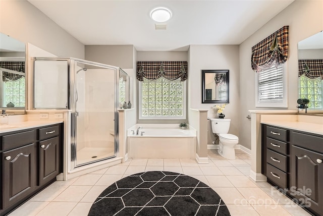 bathroom with vanity, a stall shower, a garden tub, tile patterned floors, and toilet