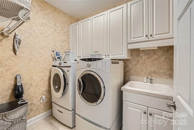clothes washing area with cabinet space, washer and clothes dryer, light tile patterned floors, and wallpapered walls