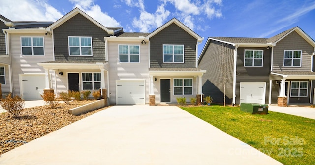 view of front of house with concrete driveway, a front lawn, and a garage