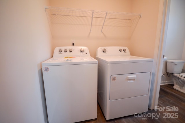 laundry area featuring dark wood finished floors, laundry area, and washer and clothes dryer