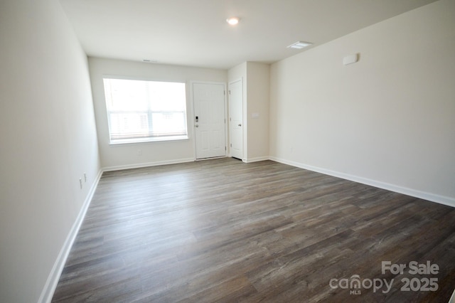 unfurnished room featuring dark wood finished floors and baseboards
