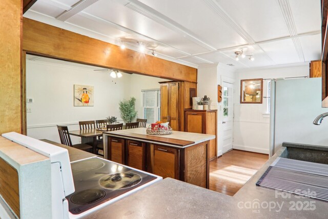 108 Patton Hill Rd, Swannanoa, NC 28778 - kitchen with light wood-style floors, a kitchen island, a ceiling fan, a sink, and brown cabinets
