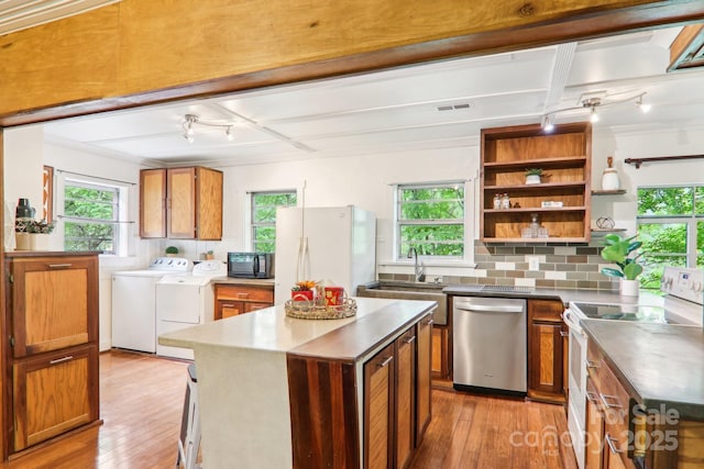 108 Patton Hill Rd, Swannanoa, NC 28778 - kitchen with white appliances, washer and clothes dryer, rail lighting, light wood finished floors, and brown cabinets