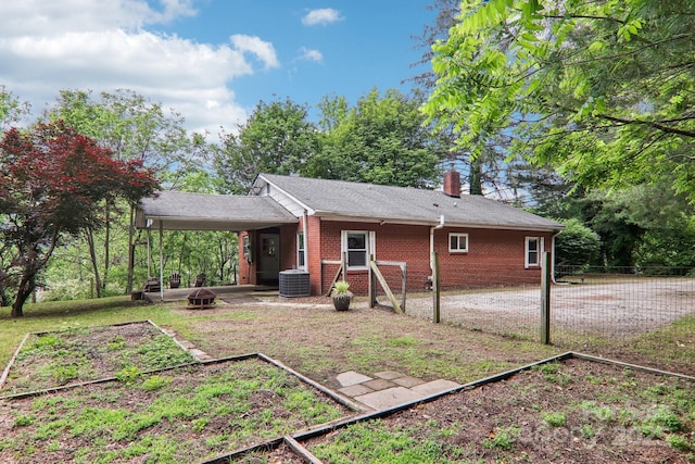 108 Patton Hill Rd, Swannanoa, NC 28778 - rear view of property with brick siding, a chimney, a vegetable garden, an attached carport, and cooling unit