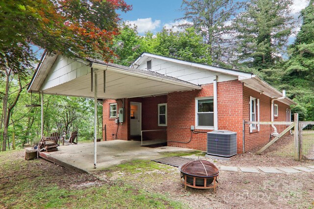 108 Patton Hill Rd, Swannanoa, NC 28778 - view of property exterior with an outdoor fire pit, central AC, brick siding, a patio area, and an attached carport
