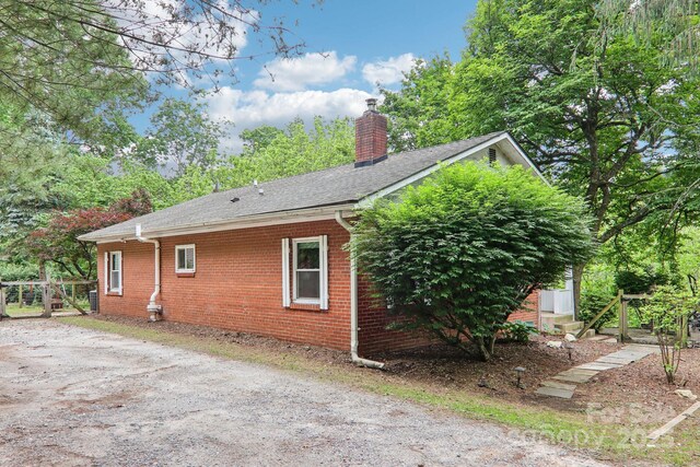 108 Patton Hill Rd, Swannanoa, NC 28778 - view of home's exterior with a chimney, brick siding, and roof with shingles