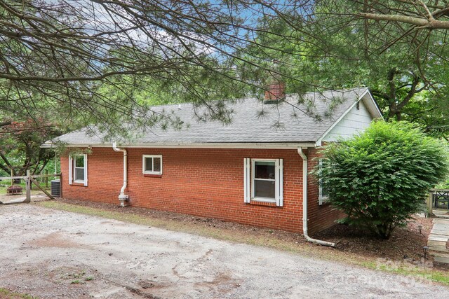 108 Patton Hill Rd, Swannanoa, NC 28778 - view of side of home with brick siding, a shingled roof, a chimney, and central AC unit