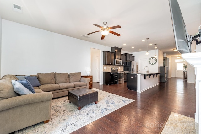 living area with ceiling fan, dark wood-style floors, visible vents, and recessed lighting