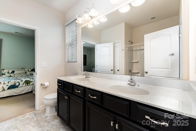 ensuite bathroom with a sink, double vanity, toilet, and walk in shower