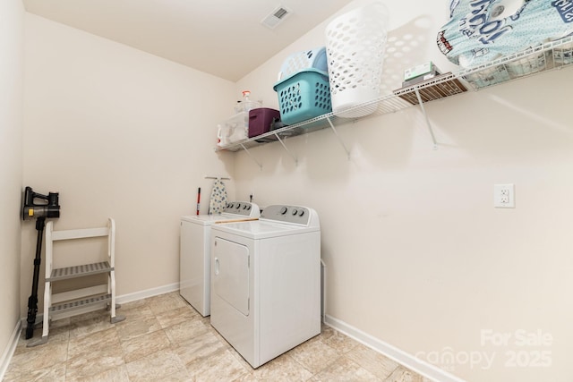 laundry area featuring baseboards, washing machine and dryer, laundry area, and visible vents