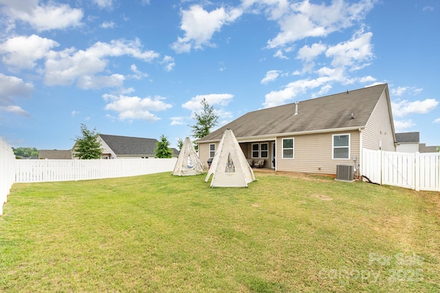 back of house featuring a fenced backyard, cooling unit, and a yard
