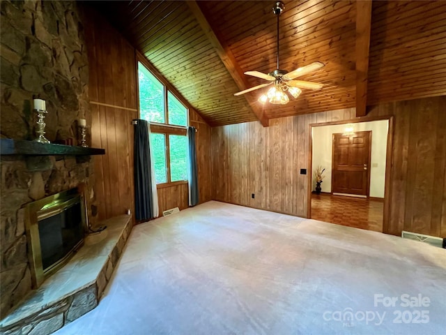 unfurnished living room featuring wooden walls, wood ceiling, carpet floors, and beamed ceiling