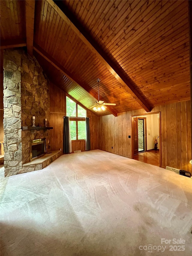 unfurnished living room with wooden ceiling, wood walls, ceiling fan, and vaulted ceiling with beams