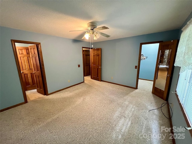 unfurnished bedroom with baseboards, light carpet, and ceiling fan