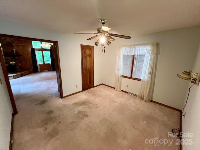 unfurnished room featuring light carpet, baseboards, a ceiling fan, and visible vents